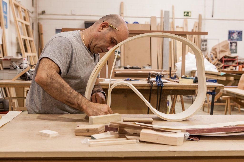 A carpenter at La Navarra working on a section of veneer for ‘Ribbon’ tables