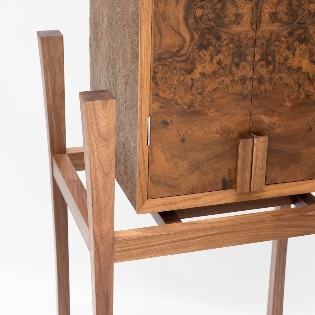 The walnut legs curve inwards on two of the faces, lightening the appearance of the whole base of the cabinet