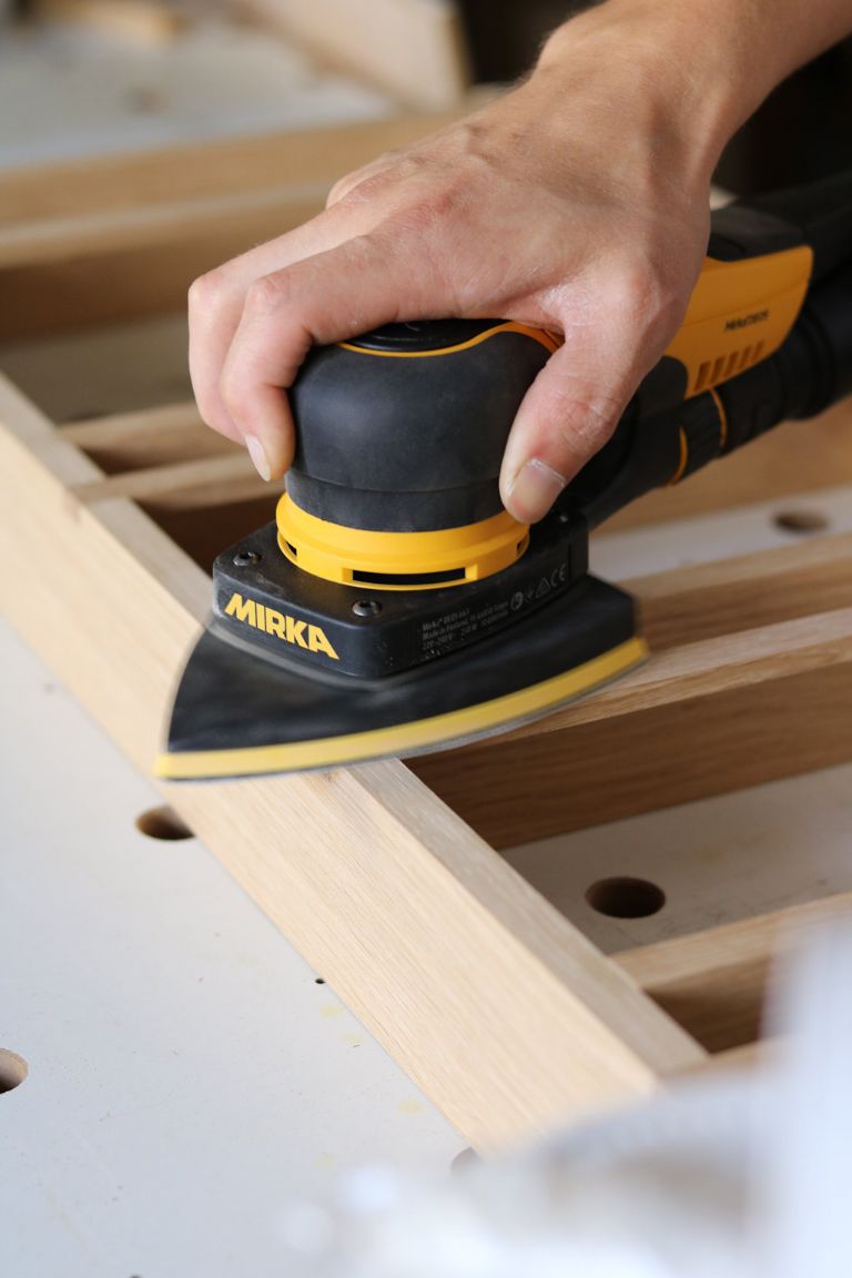 The Mirka DEOS Delta 663CV corner sander’s triangular shape base pad with 3mm orbit pattern